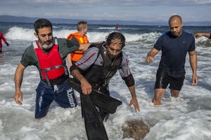 Gabriel Green Volunteers take a possible smuggler to shore on Lesvos, Greece Saturday afternoon after the man was rescued by two Spanish lifeguards as he attempted to float back to Turkey on a partially deflated raft after delivering a group of refugees. He was later delivered by volunteers from Drop in the Ocean to a police station in Molyvos.